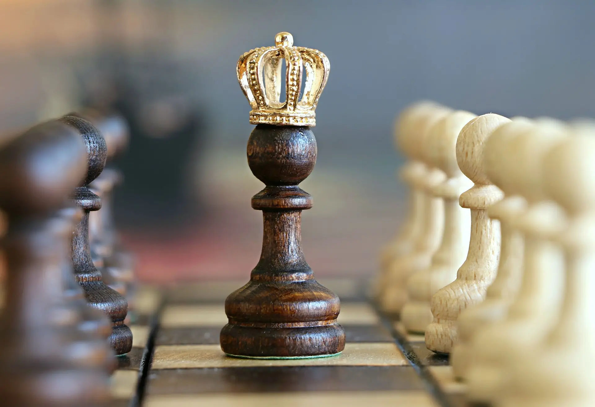Chess king standing in front of a line of pawns