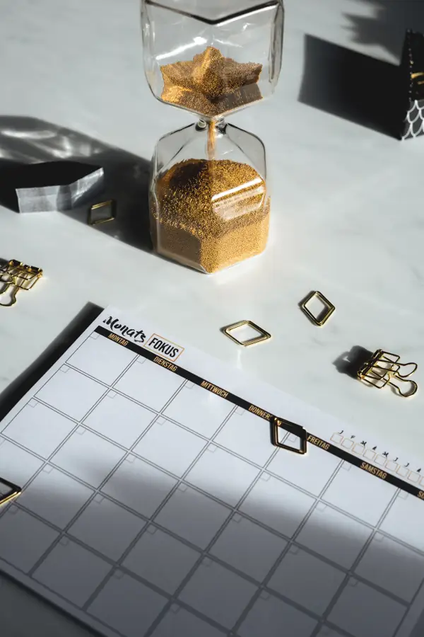 Hourglass standing beside a desk calendar