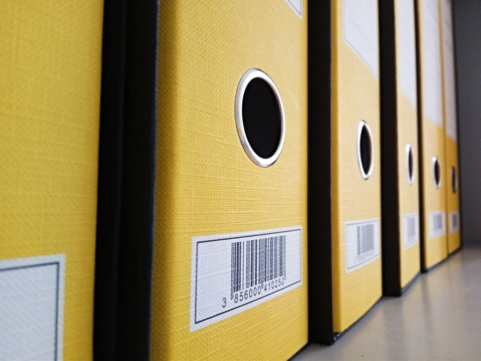 Row of yellow lever-arch files lined up on a shelf